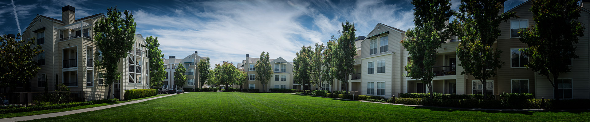 Panorama view apartment building complex with grassy backyard